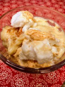 A bowl of ice cream with whipped cream on top.