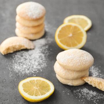 homemade cookies with lemon flavor and sliced fruit on table