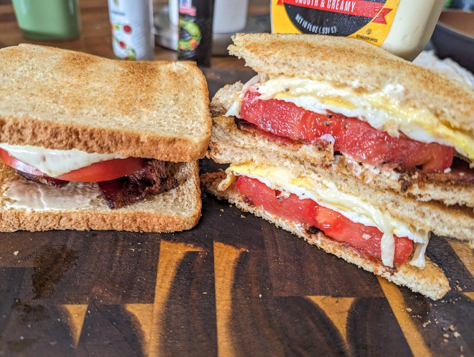 fried egg tomato sandwich on butcher block