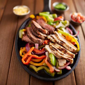 mexican steak and chicken fajitas in cast iron skillet shot top down