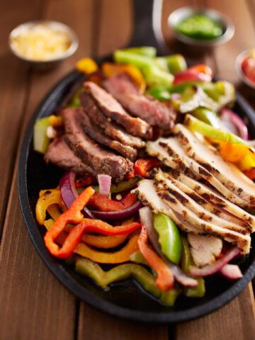mexican steak and chicken fajitas in cast iron skillet shot top down